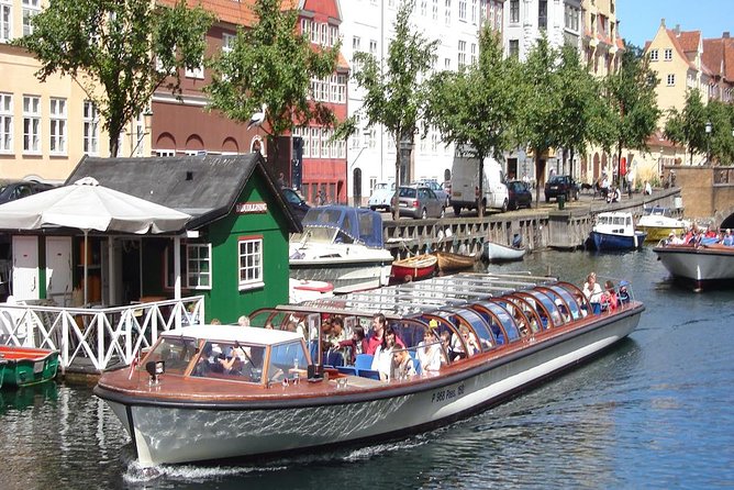 A canal boat passing the coloured houses of a Copenhagen canal